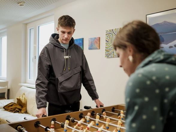 Zwei Jugendlichen spielen am  Kicker im Aufenthaltsraum 