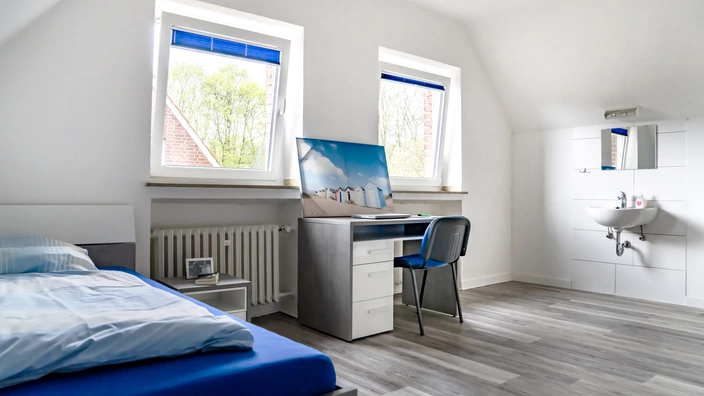 Beispielzimmer im Lernort Wohnen (Bett, Schreibtisch und Waschbecken)