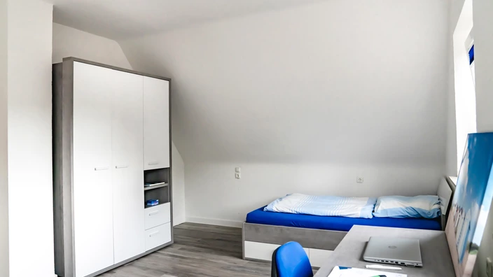 Beispielzimmer im Lernort Wohnen (Kleiderschrank, Bett und Schreibtisch)